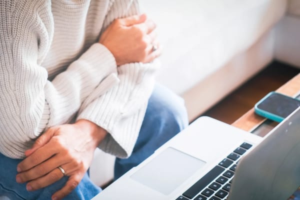 Woman relaxing at home with laptop for telehealth session